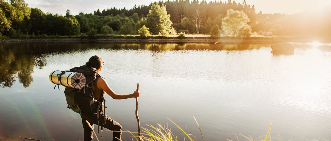 En vandrare tar en paus vid en sjö i Skåne