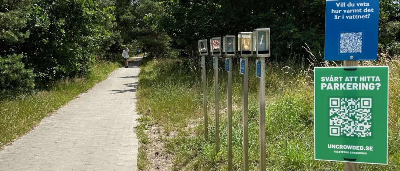 En gångväg med informationsskyltar vid sidan. Foto.