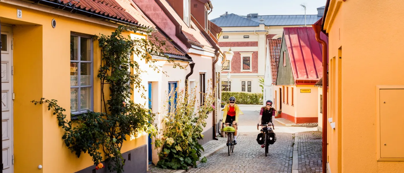Två cyklar i Ystad med gula hus