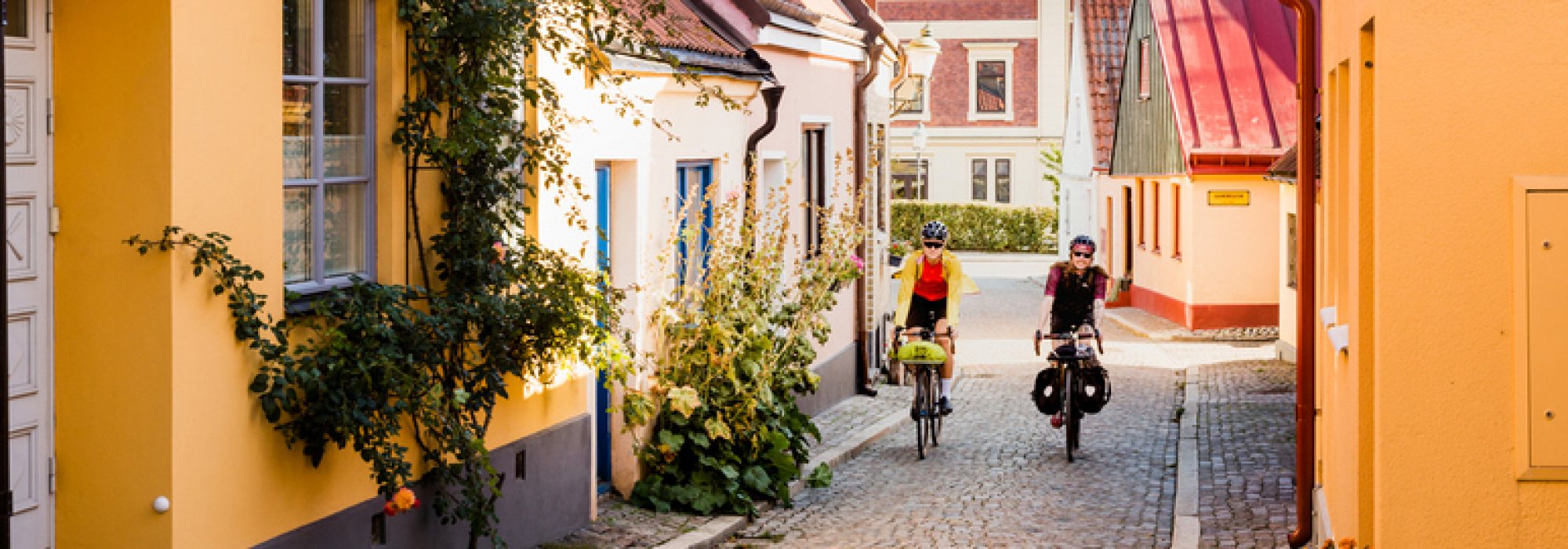 Cykelturister på kullerstensgata i Ystad. Foto.