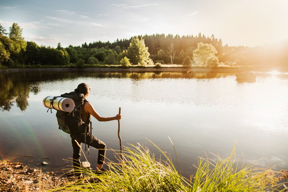 En vandrare tar en paus vid en sjö i Skåne