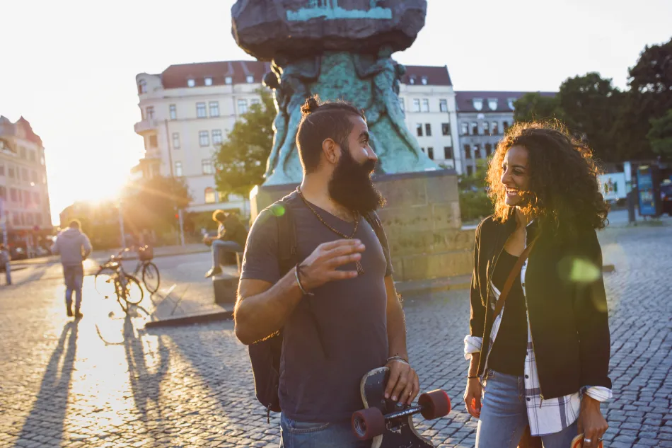 Ett par står på ett torg och samtalar. Foto.