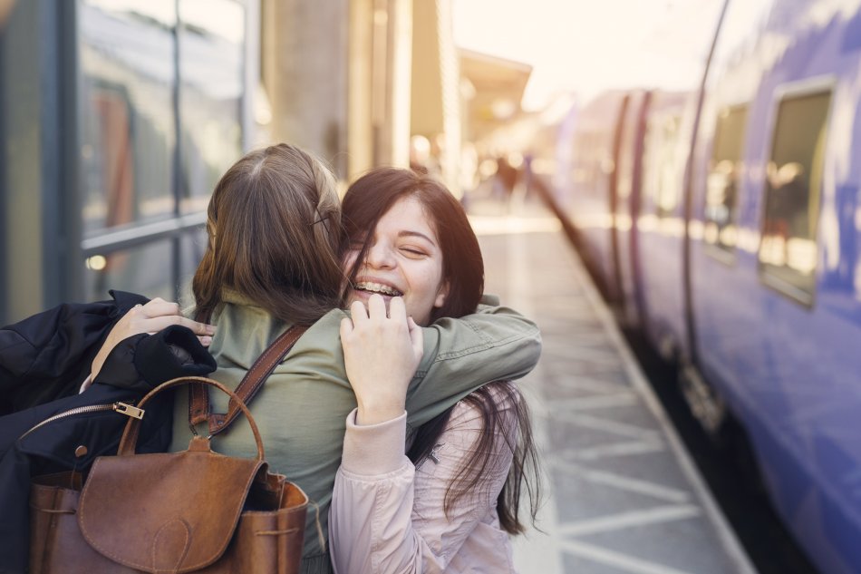 Två personer kramar varandra på tågperrong