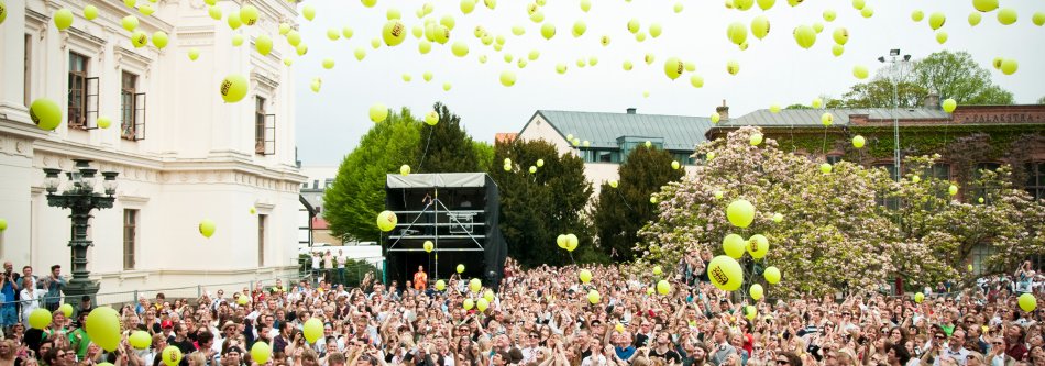 Folkmassa med gula ballonger