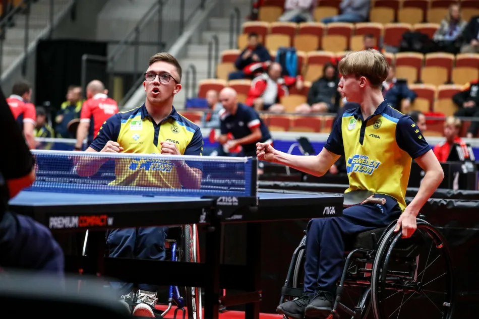 Rullstolsburna bordtennisspelare spelar match i Sverigetröjor. Foto.