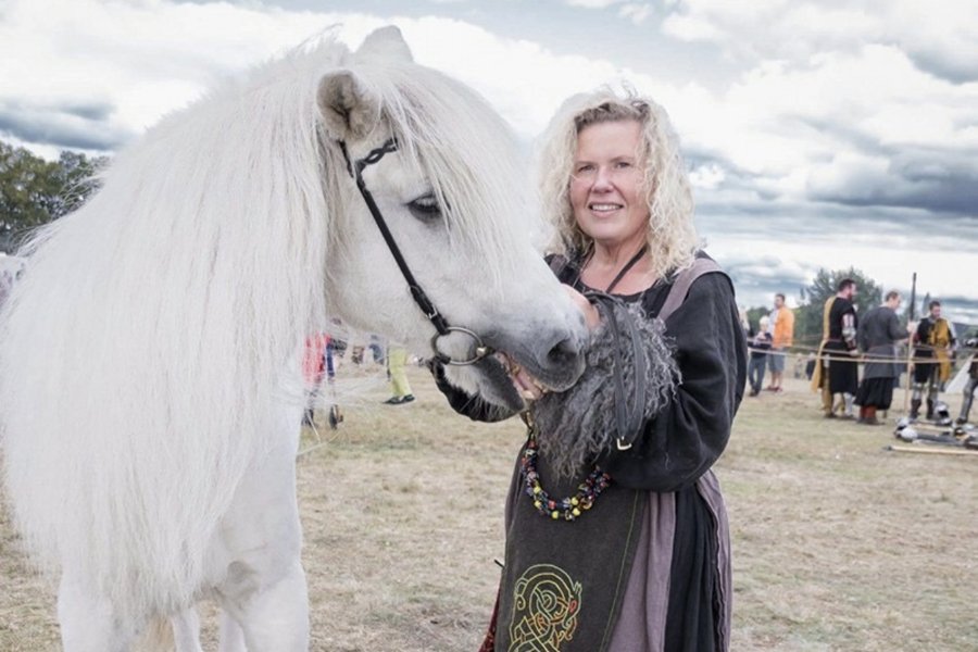 Kvinna i vikingadräkt med häst. Camilla Stark från Gudahagen. Foto.