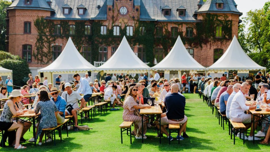 Massa ätande och drickande folk på Skåne Food Fest med Sofieros slott i bakgrunden