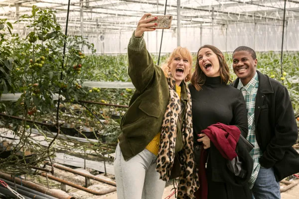 Tre personer tar en selfie i ett växthus.